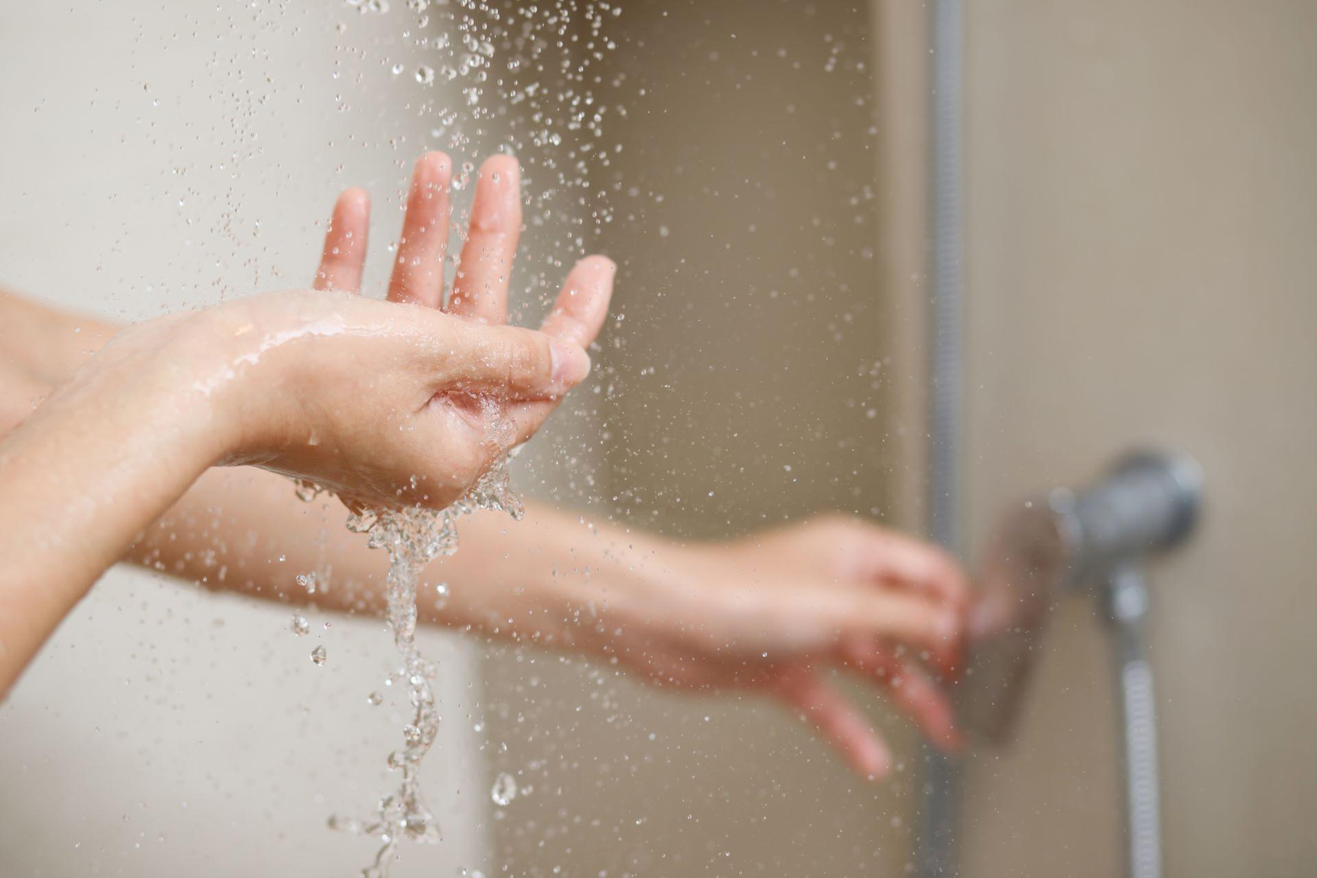 Hand unter weichem Duschwasserstrahl