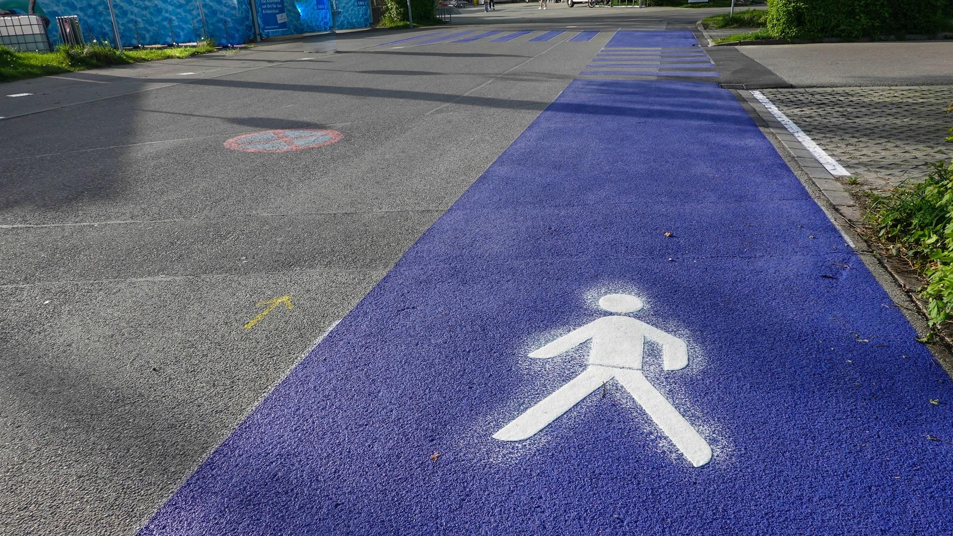 Blauer Weg mit Straßenmarkierung für Fußgänger