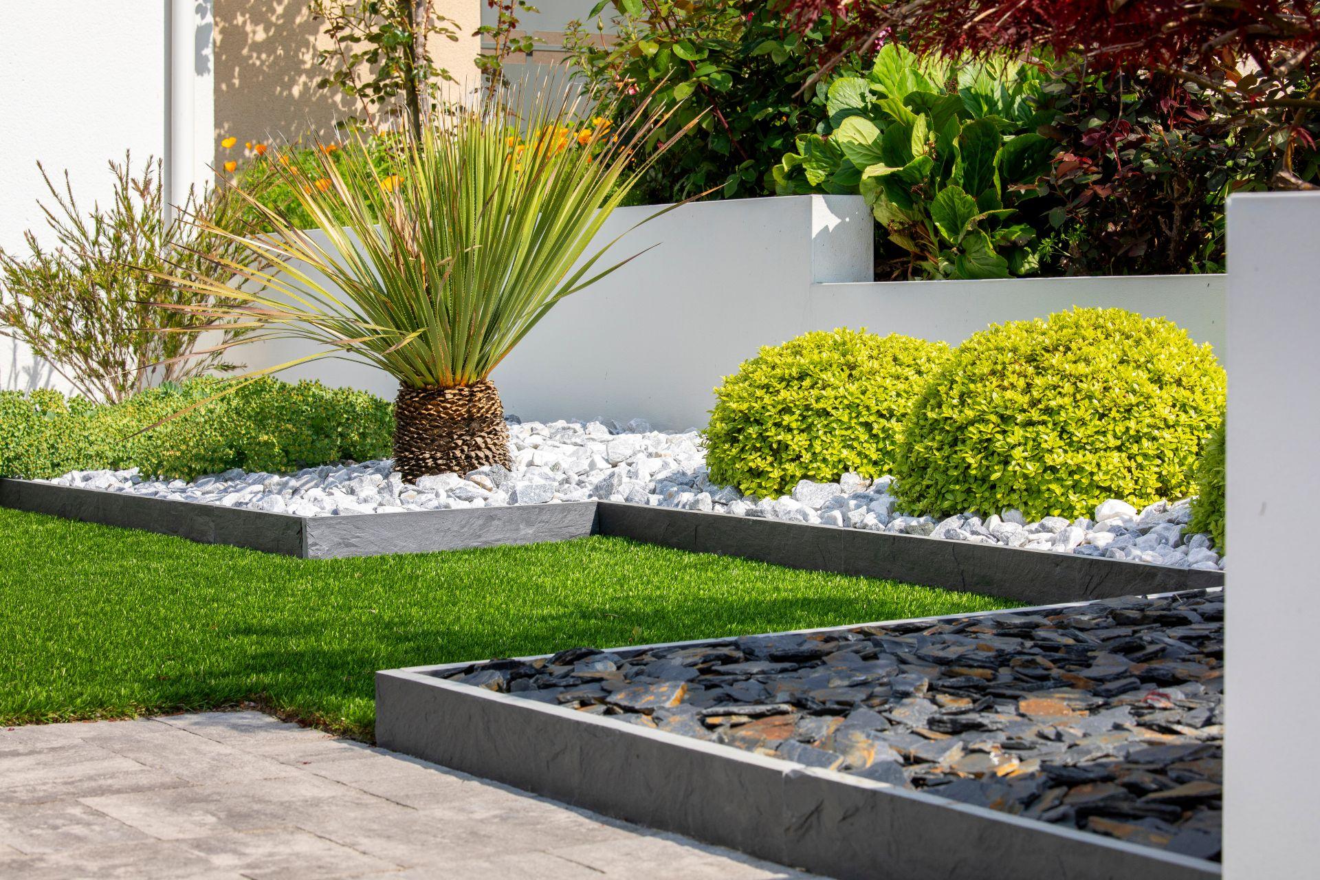 moderner garten mit grauen und weissen ziersteinen sowie geometrischer bepflanzung